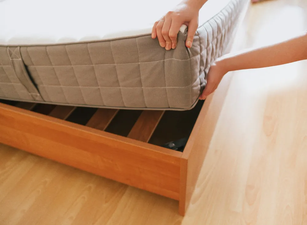 Colchón de 135x190 colocado sobre un somier de láminas de madera