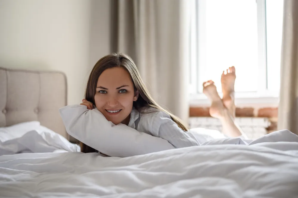 Mujer despertándose descansada gracias a un buen colchón